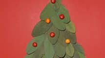 Biglietto con albero di natale fatto di foglie e bacche