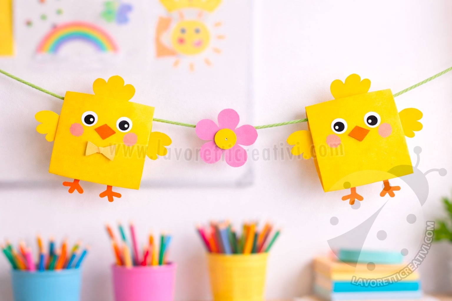 Ghirlanda di pulcini con strisce di carta in classe, appesa con filo colorato.